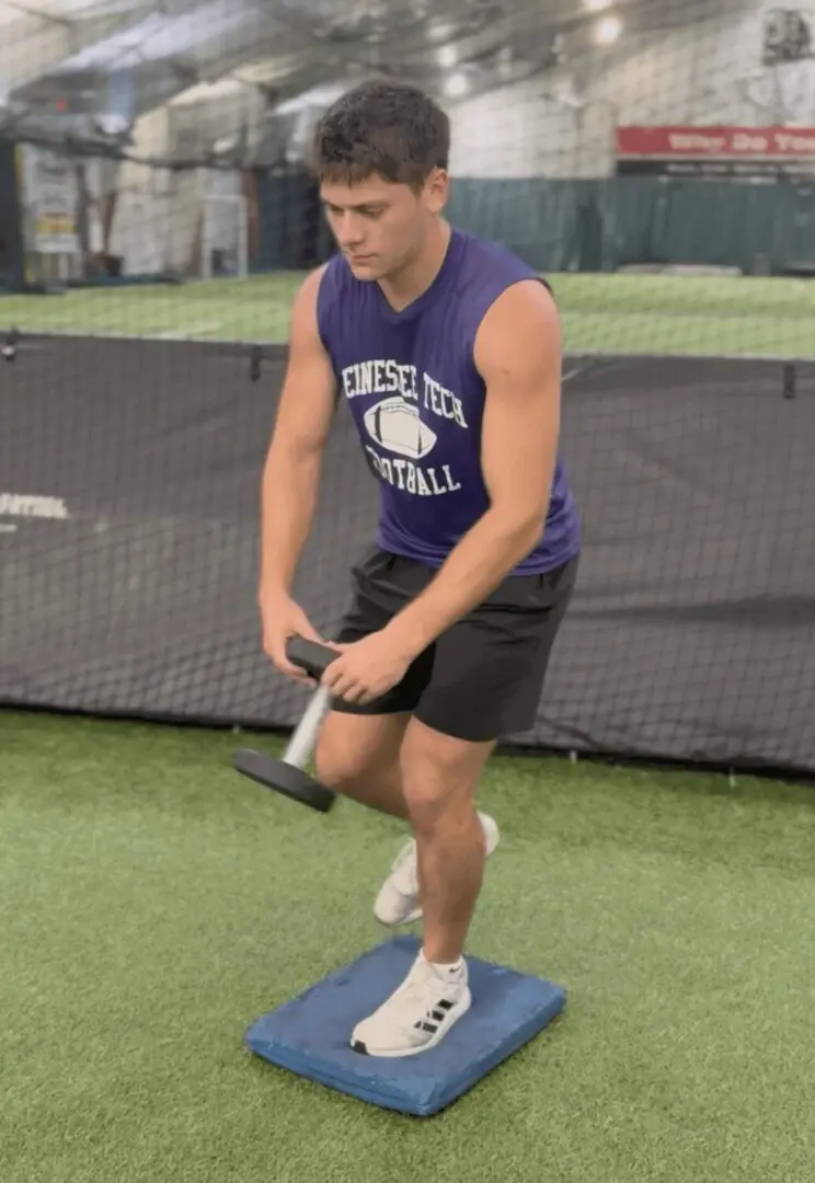 Man balancing on pad during workout.