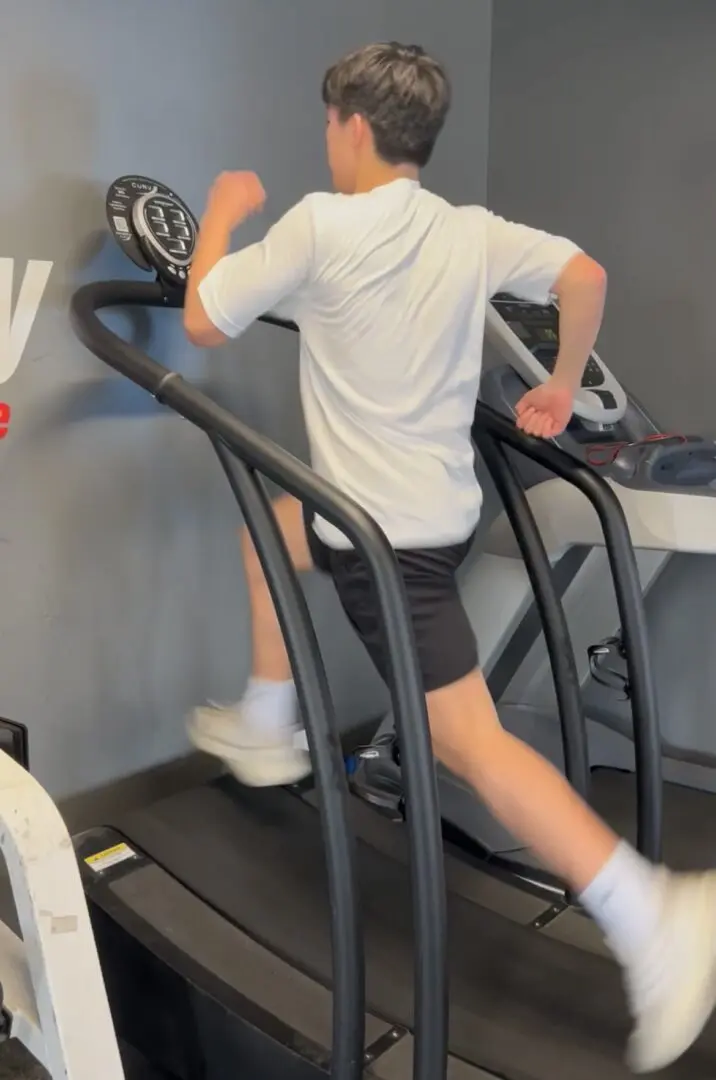 Person running on a curved treadmill.