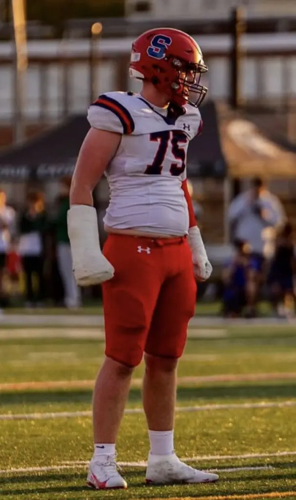 Football player number 75 standing on field