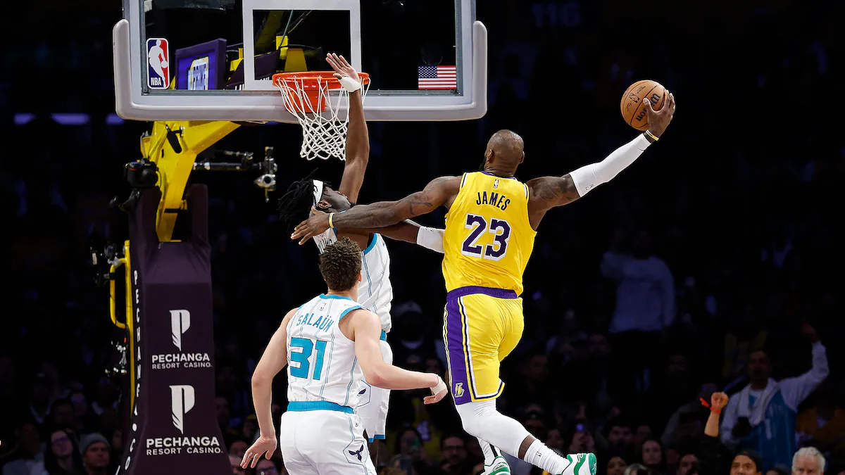 Basketball player in yellow jersey driving to hoop