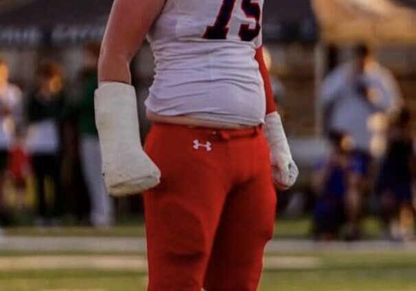Football player number 75 standing on field