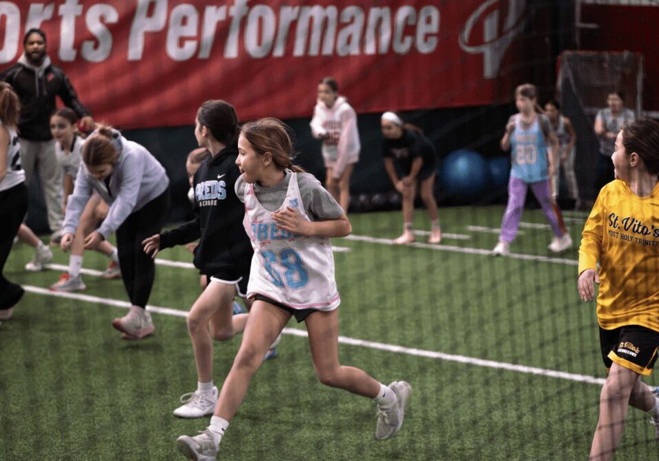 Kids playing sports indoors on a artificial turf.