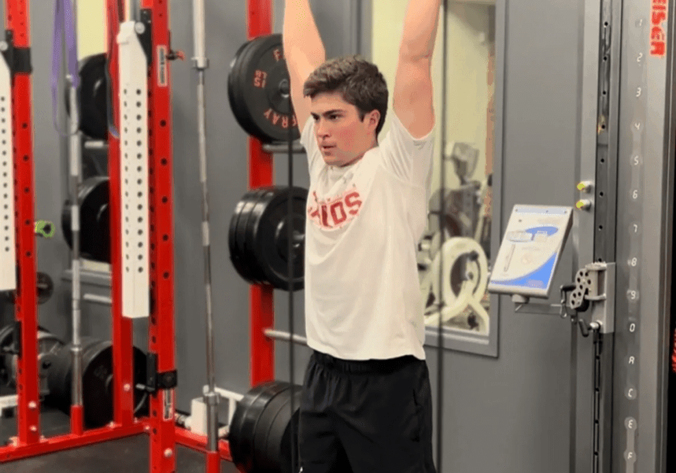Man exercising with resistance band in gym.