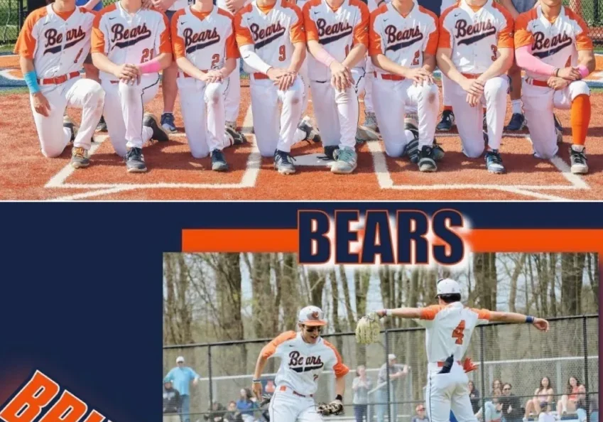 Youth baseball team posing with a banner celebrating a win.